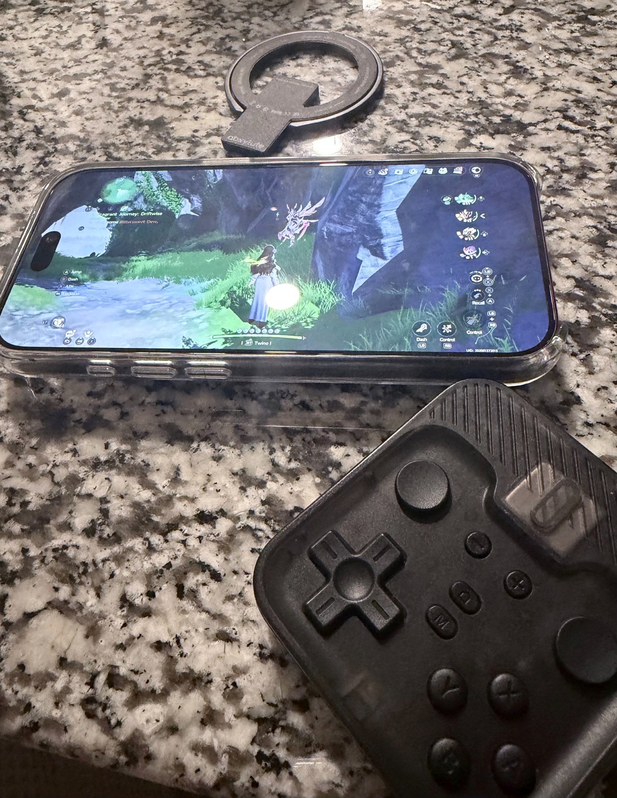 abxylute M4 controller detached beside a phone and its magnetic mounting ring